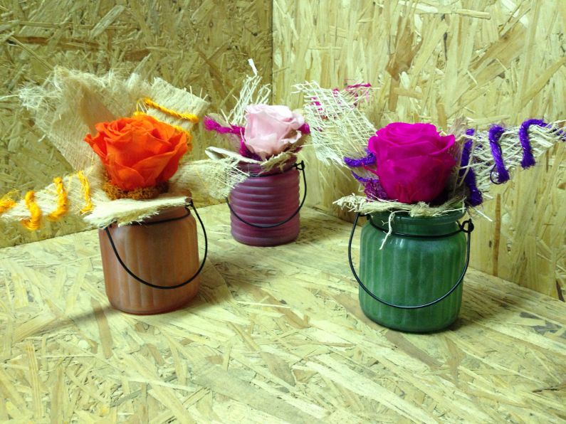 Portalumino in vetro colorato con rosa stabilizzata colorata arricchita di foglia di palma sbiancata e decorazione in sisal colorata